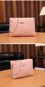 Detail of pink PU leather handbag with heart quilting, gold metal clasp and chain strap