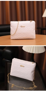 Detail view of pink crossbody bag with heart quilting and elegant gold chain strap