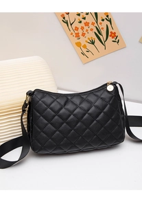 Detail of black quilted shoulder bag with gold zipper and durable canvas strap