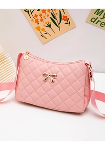 Detailed shot of pink quilted shoulder bag featuring a gold bow and metal zip charm