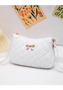 Detail of white quilted crossbody bag with golden bow clasp and woven strap