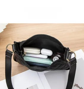 Vue intérieure du sac bandoulière matelassé noir montrant plusieurs compartiments