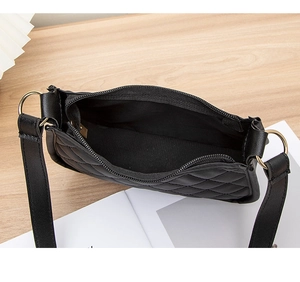 Détail d'un sac à bandoulière matelassé noir avec poche intérieure zippée et doublure