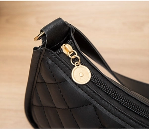 Détail de la texture du cuir matelassé noir et fermeture éclair en métal doré premium