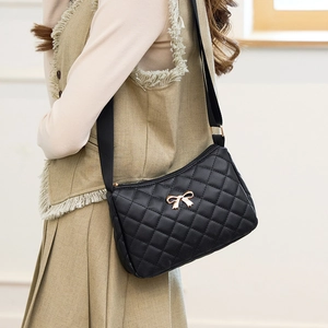 Quilted black crossbody bag with golden bow accent worn by model for daily styling