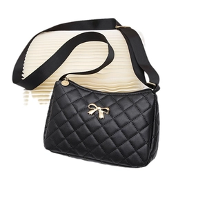 Classic black quilted crossbody bag featuring a golden bow and adjustable shoulder strap