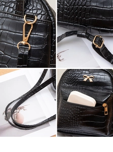 Detail of black crocodile texture mini backpack with gold hardware and bow charm