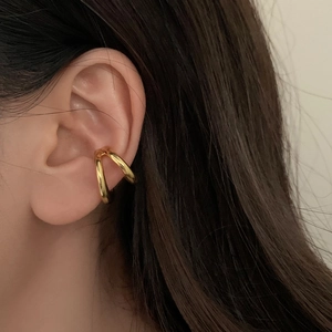 Minimalist double layer gold ear cuff shown in a detailed close-up on a model's ear