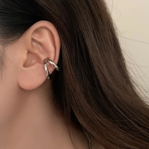 Close-up of silver double-layered ear cuff with a minimalist cross design on the ear
