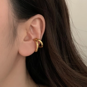 Close-up of a double-layered gold ear cuff worn on the ear bone for a minimalist look