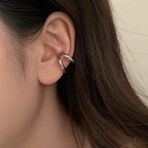 Close-up of minimalist silver double-layer ear cuff on a model's ear without piercing