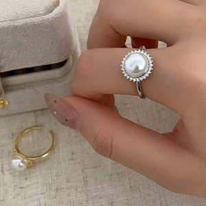 Detailed macro view of an elegant open pearl ring with micro-set zircon accents