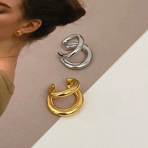 Minimalist double layer ear cuff in gold and silver finish on fashion magazine background