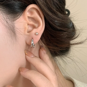 Silver pearl hoop earrings and minimalist stud set worn on ear for vintage style