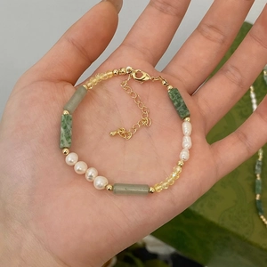 Detailed view of handmade beaded necklace with green stones and freshwater pearls