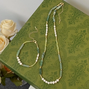 Close-up of pearl and green stone necklace jewelry set on a vintage gift box