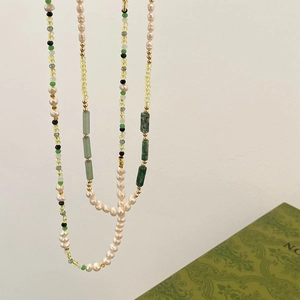 Detail van handgemaakte ketting met parels, groene jade en kleurrijke steentjes