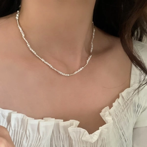 Minimalistische silberne Perlenkette mit facettierten Röhrchen am Modelhals