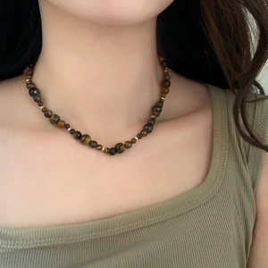Gros plan d'un collier de perles en oeil de tigre avec perles d'espacement en argent
