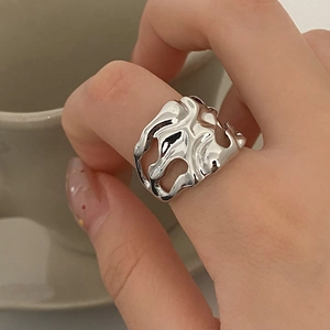 Close-up of liquid metal style open ring with irregular hollow design on model hand