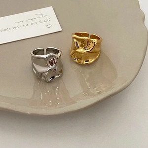 Detail of adjustable metal ring with irregular lava texture in gold and silver