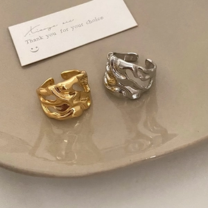 Irregular lava texture gold and silver open rings displayed on a ceramic tray