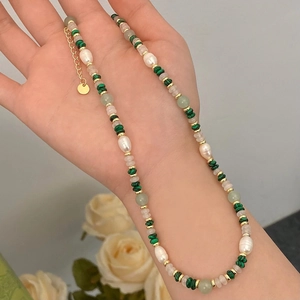 Elegante Perlenkette mit Süßwasserperlen und grünem Malachit in der Hand gehalten