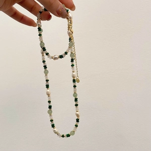 Detail einer Perlenkette mit Süßwasserperlen, grünen Natursteinen und Gold-Metallelementen