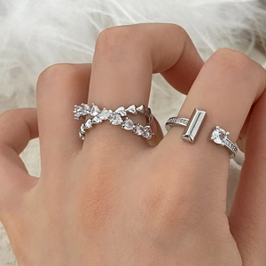 Elegant silver-toned T-shaped open ring and layered heart zircon ring on white fur