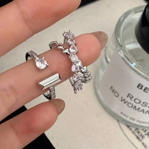 Detail of elegant silver rings with micro-pave cubic zirconia and heart design on finger