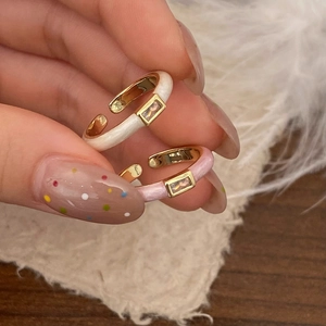 Detalle de anillos ajustables de esmalte con circonita lucidos en una mano