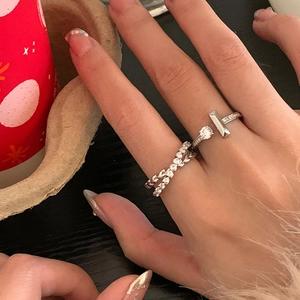 Detail of silver heart rings with pave cubic zirconia and twisted band on a finger