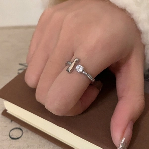 Close-up of silver open ring featuring a round zircon stone and micro-pave setting