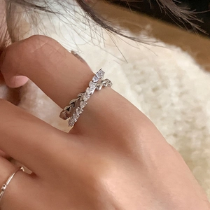 Macro detail of silver double-layer ring with sparkling zircon and leaf pattern