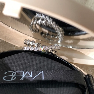 Detailed shot of silver heart ring and micro-pave eternity band on a mirror surface