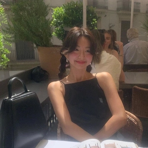 Minimalist U-shaped silver earrings worn in a lifestyle outdoor cafe setting