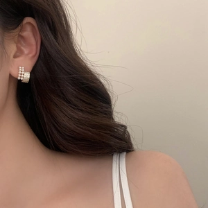 Elegant French style pearl and zircon stud earrings on model with gold metal base