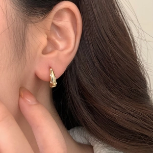 Close-up of gold hoop earrings with micro-set cubic zirconia on female model