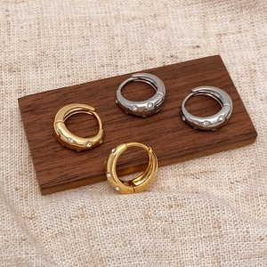Chic micro-paved zircon hoop earrings in gold and silver finish on a rustic linen background