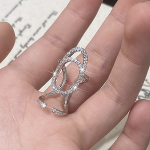 Close-up of double oval silver ring with pave zircon stones on hand-held display