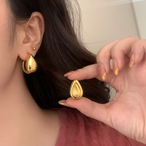 Minimalist gold teardrop earrings in 3D hollow design worn by model for elegant style