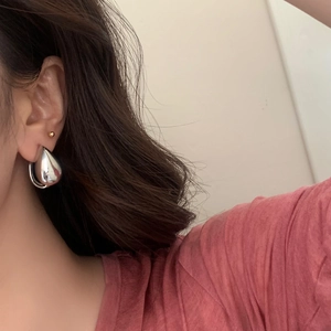 Polished silver teardrop earrings on model showcasing minimalist modern aesthetic