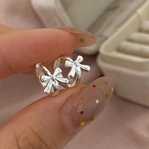 Elegant bow knot silver hoop earrings for women shown in a soft pink jewelry box