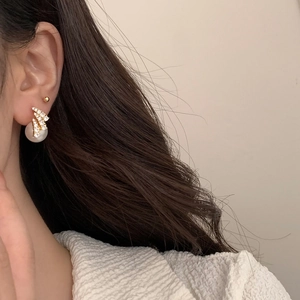 Elegant pearl and sparkling zircon earrings with gold finish on model ear