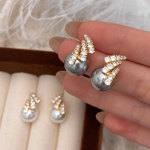 Elegant pearl stud earrings with sparkling zircon feather setting in gold finish