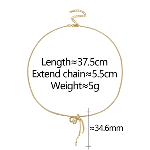 Détail du collier nœud doré avec accents en strass et chaîne serpent avec extension