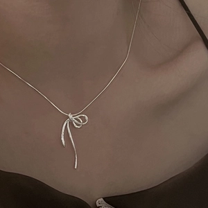 Gros plan sur un pendentif nœud argenté avec une chaîne serpent élégante pour femme