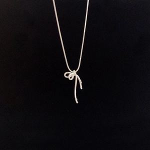 Collier élégant pour femme avec pendentif nœud en argent sur une fine chaîne minimaliste