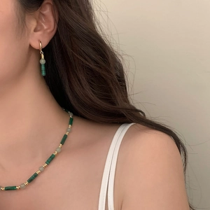 Détail du collier et boucles d'oreilles en perles de malachite sur mannequin