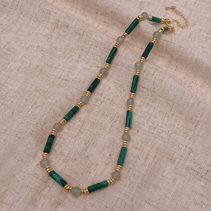 Détail de perles en malachite et entretoises dorées sur toile avec fermoir mousqueton